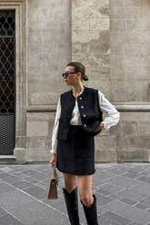 a lady in a white shirt, a black tweed vest and a black tweed skirt